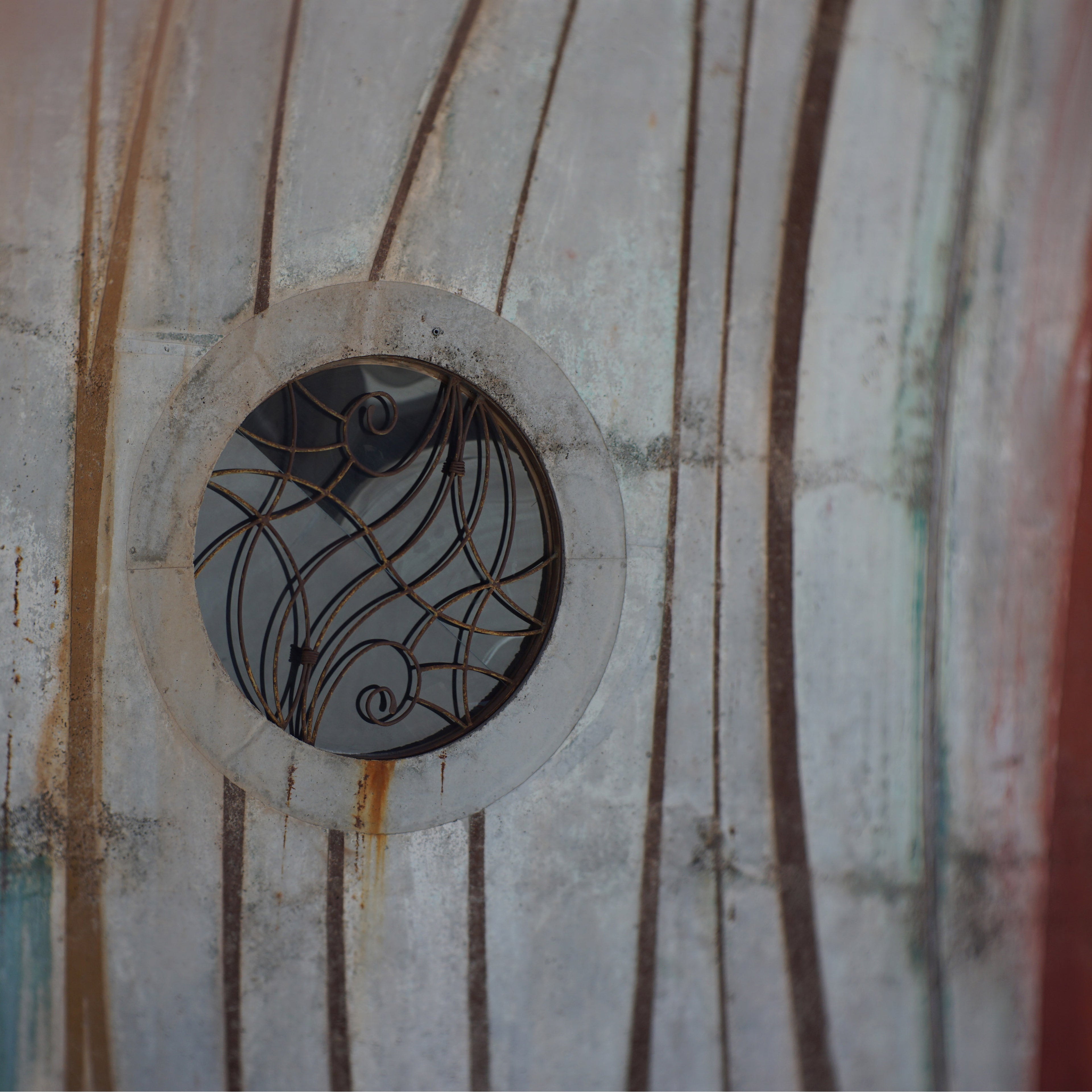 The circular window within the vaults with a beautiful iron gate on top.